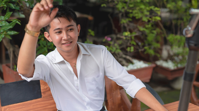 A dinner guest politely seeking the serving staff's attention