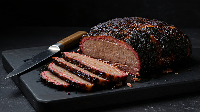 Smoked brisket on a board with four pieces sliced off