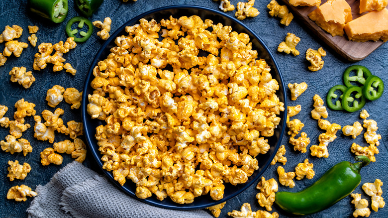 A bowl of seasoned popcorn with fresh jalapeños