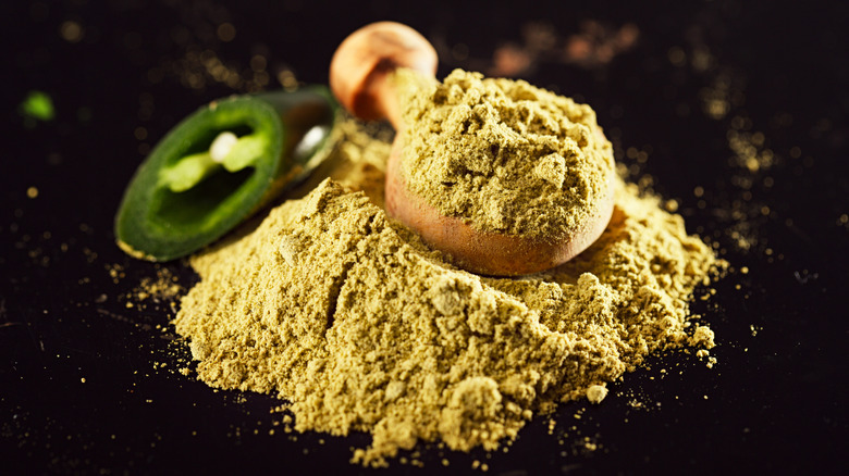 A spoonful of jalapeño powder with fresh jalapeño