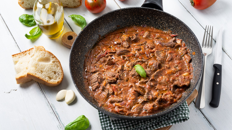 steak pizzaiola in a black frying pan