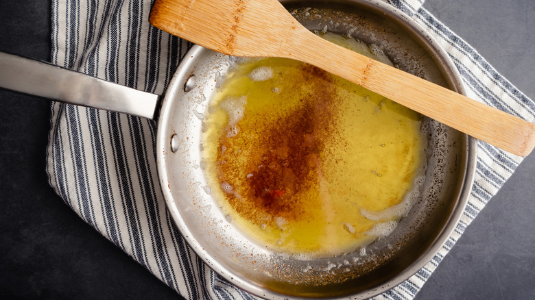 butter browning in frying pan with wooden spoon resting on rim