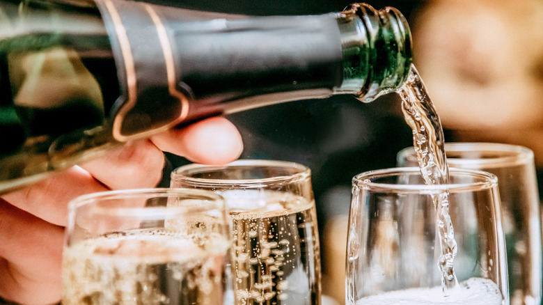 Pouring a bottle of sparkling wine into glasses