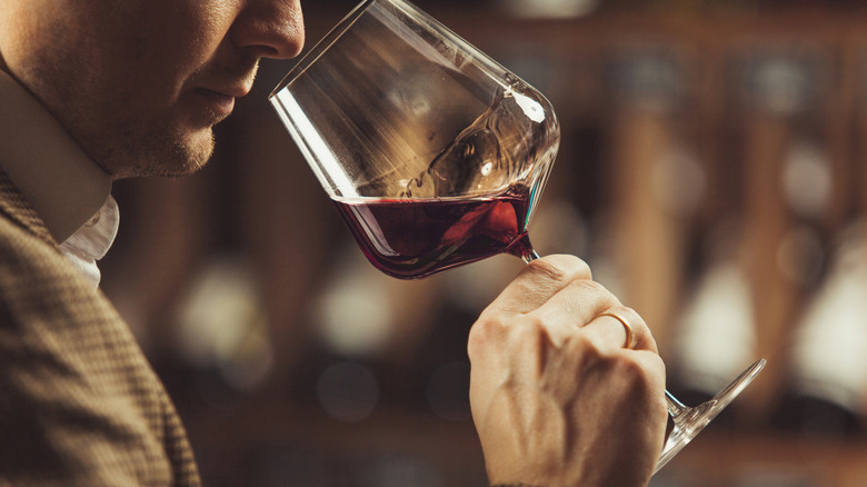 Close up of man smelling red wine