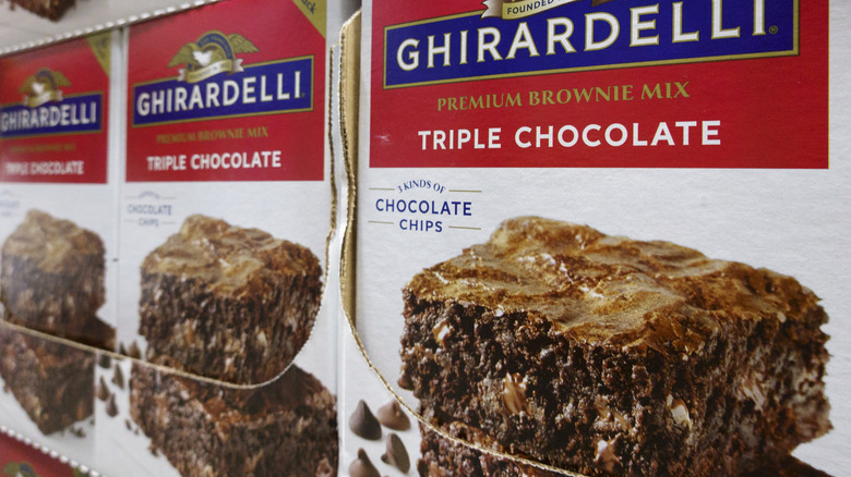 Three boxes of Ghirardelli brownie mix at a store