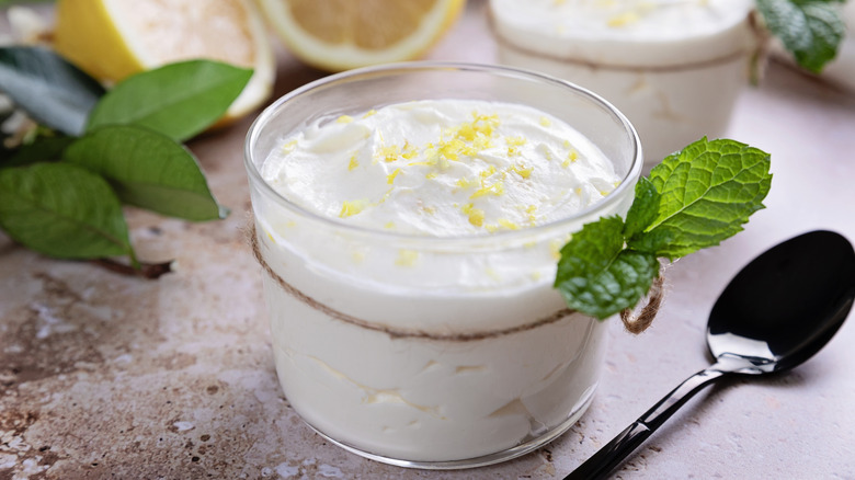 Glass dish of plain yogurt with lemon zest and mint