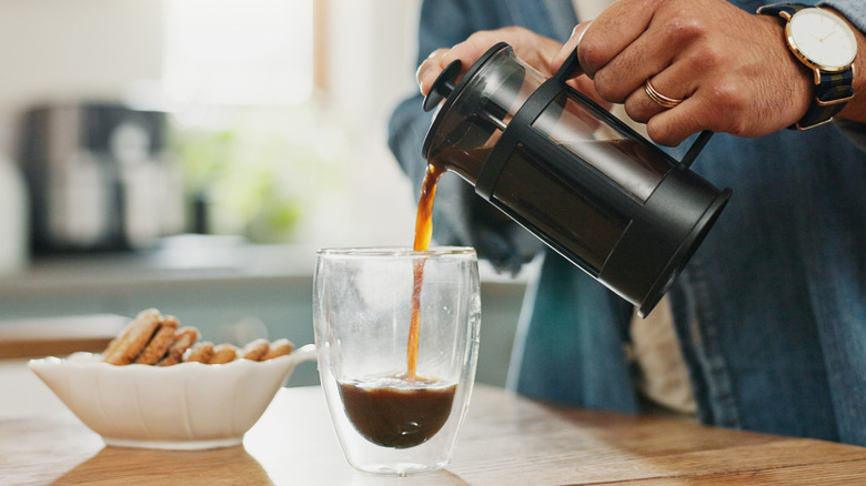 Pouring coffee from French press into mug