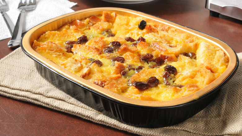 A dish of bread pudding topped with raisins.