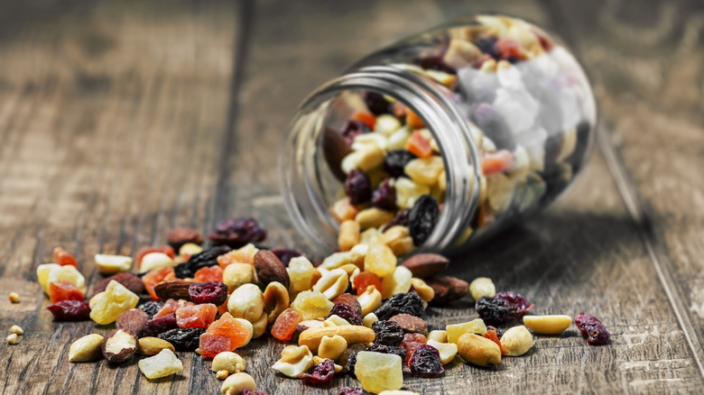 Glass jar of trail mix on a wooden table