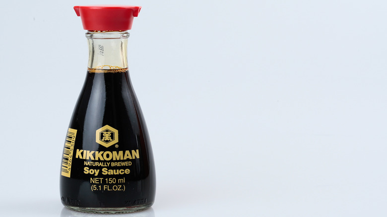 A small bottle of Kikkoman soy sauce with a red double spout cap.