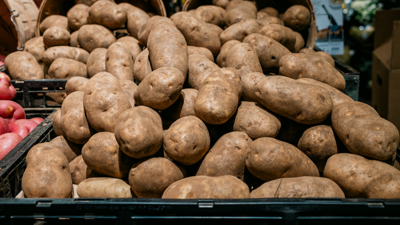 Piles of potatoes at a store in black crates