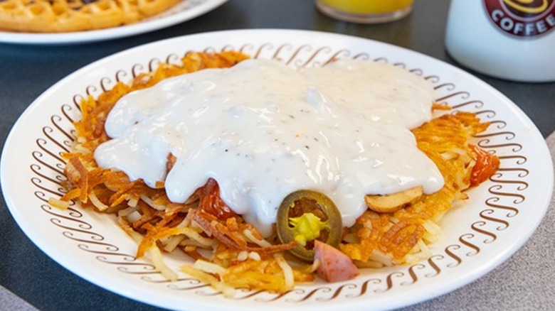 A plate of Waffle House hashbrowns with gravy, jalapenos, and ham