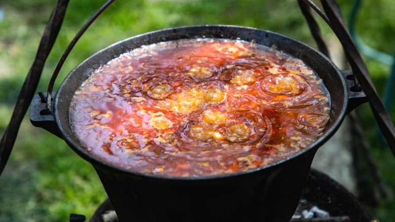 Olla de chili cocinando sobre una fogata