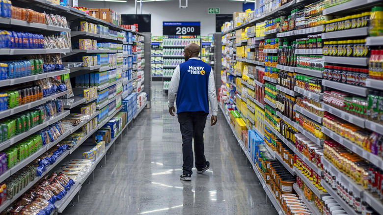 Walmart employee walking down grocery store aisle