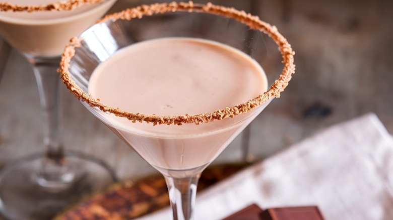 Chocolate martini with chocolate squares in background.
