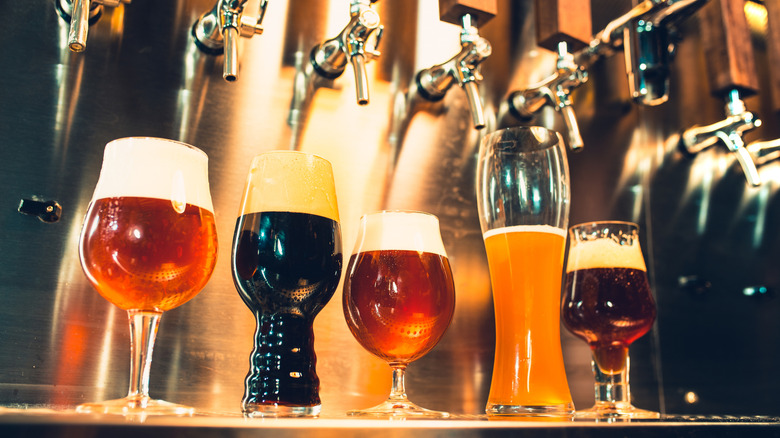 Variety of beer styles and glasses lined up on tap