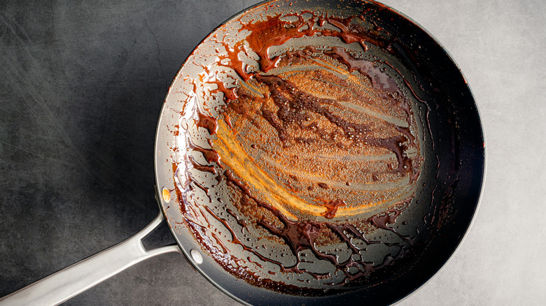 A nonstick frying pan with stuck on sauce residue