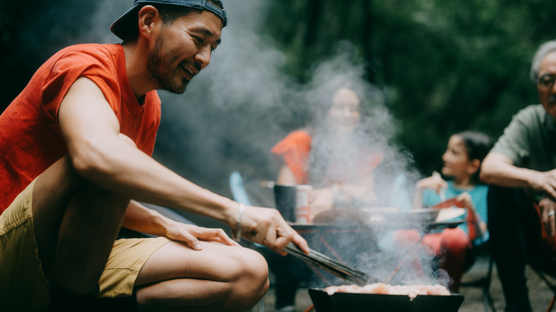 Man cooking barbecue on a small grill