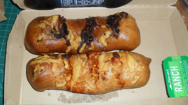 Two Pizza Hut P'zolos on cardboard packaging, with a side of ranch dipping sauce