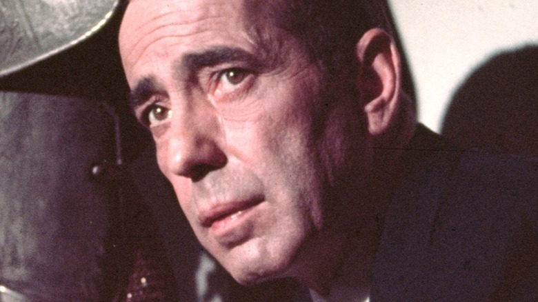 Humphrey Bogart next to a suit of armor