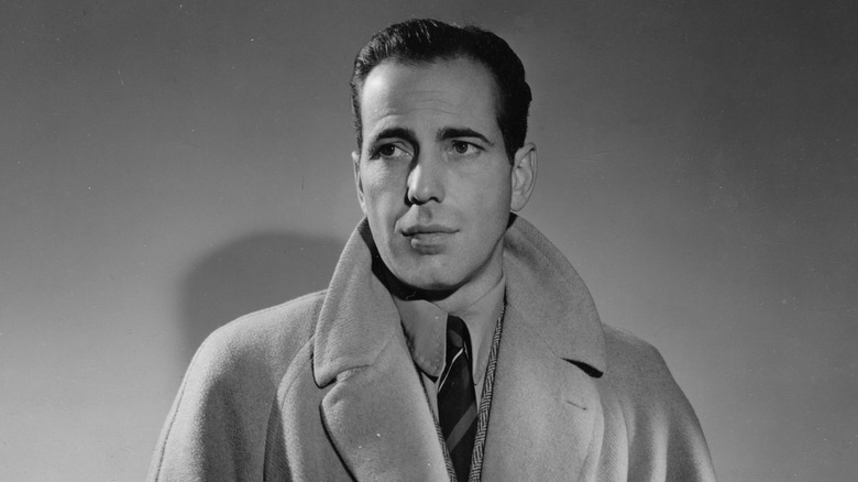 Black and white photo of Humphrey Bogart wearing a trench coat