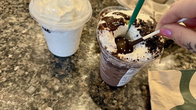 Dunking a chocolate cake pop into a Starbucks drink