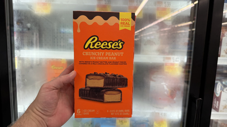 Hand holding a box of Reese's Crunchy Peanut Ice Cream Bars