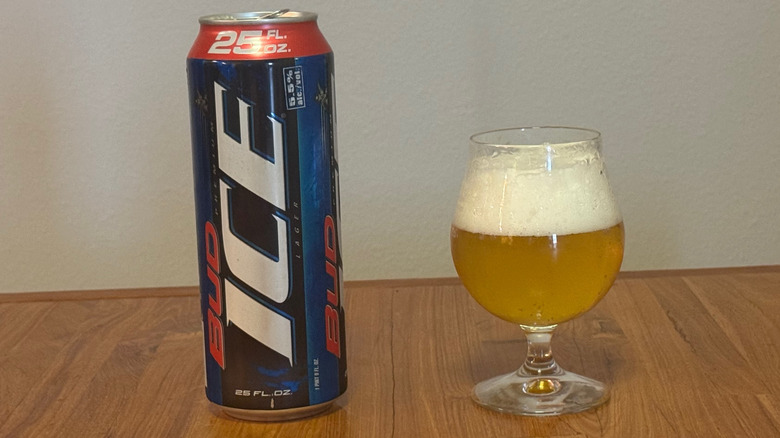 A 25 ounce can of Bud Ice next to a beer goblet that has a large head of foam over a yellow beer.