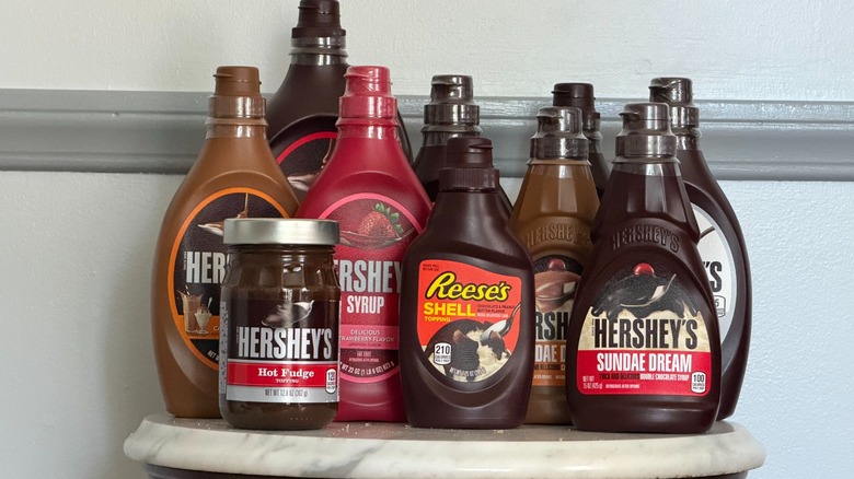 10 containers of Hershey's syrups and sauces on a small table