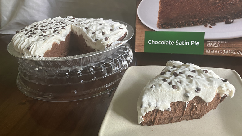 A slice of Marie Callender's Chocolate Satin Pie next to its box and the rest of the pie in its tin