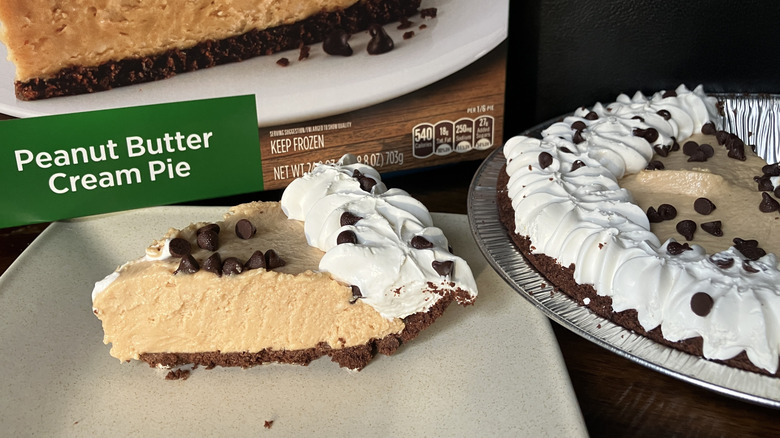 A slice of Marie Callender's Peanut Butter Cream Pie next to its box and the remaining pie in its tin