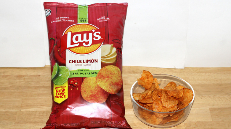 A bag of Lay's Chile Limón potato chips beside a bowl full of chips