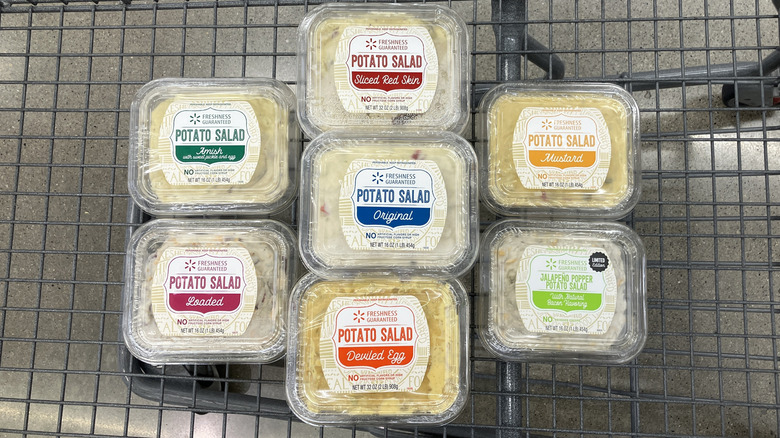 Seven tubs of potato salad in a shopping cart