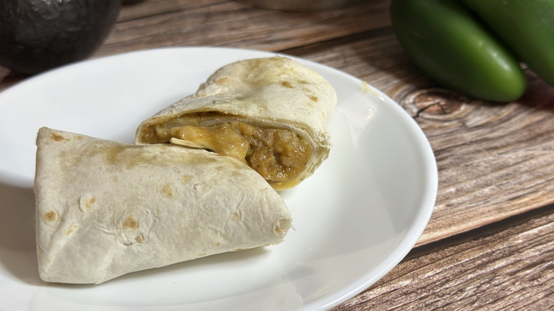 El Monterey Signature Shredded Steak & Cheese Burrito on white plate with jalapenos