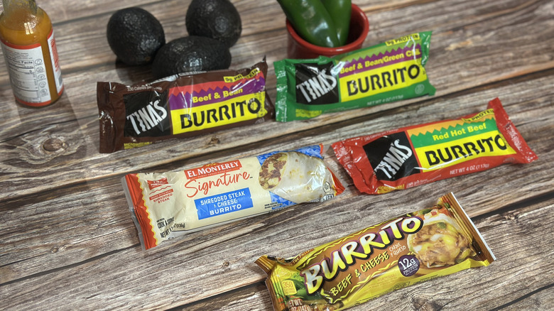 Frozen beef burritos lined up with avocado, jalapeños, and a bottle of sauce