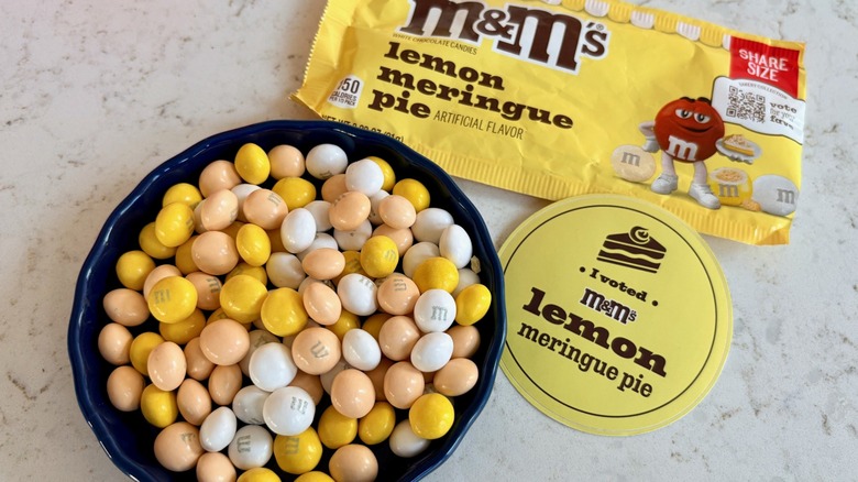 An bag of M&M's lemon meringue pie candies in a bowl with a yellow I voted sticker for Flavor Vote