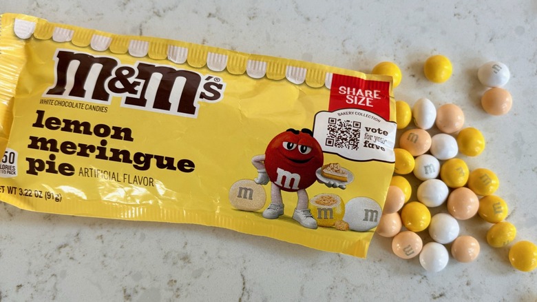 An open bag of M&M's lemon meringue pie candies poured on a counter