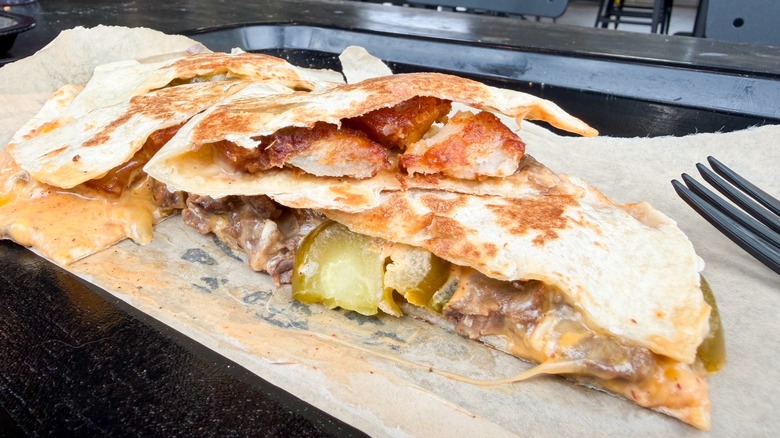 Quesadilla with crispy potatoes, steak, jalapeños, nacho cheese sauce, and cheddar