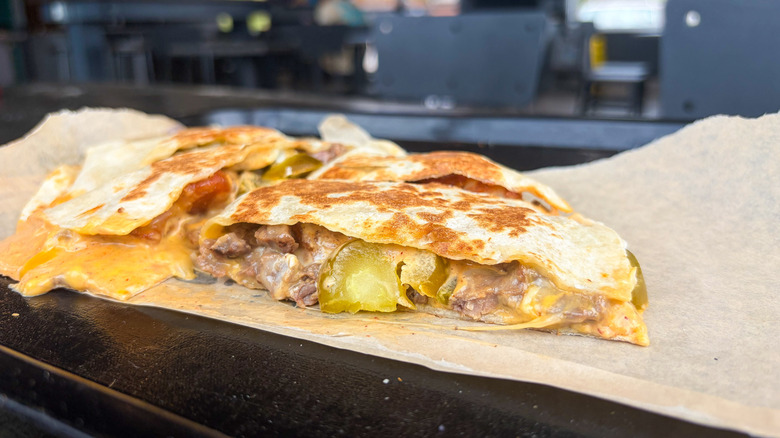 Quesadilla with steak, jalapeños, nacho cheese sauce, potatoes, and cheddar