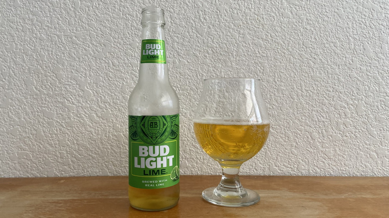 Bud Light Lime bottle beside tulip glass half-full of beer
