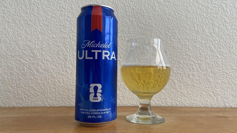 Michelob Ultra tall can beside tulip glass half-full of beer