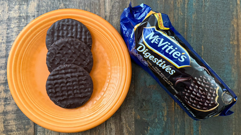 A plate of McVitie's dark chocolate digestive biscuits next to the package