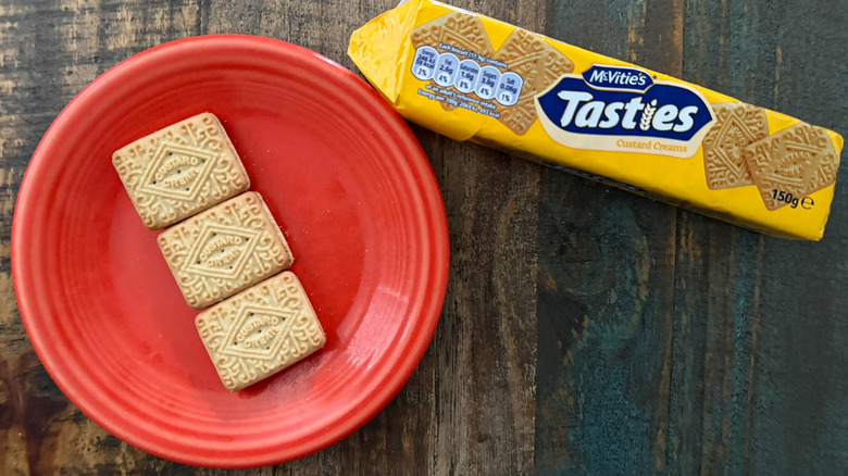 A plate of McVitie's Tasties custard cream biscuits next to the package