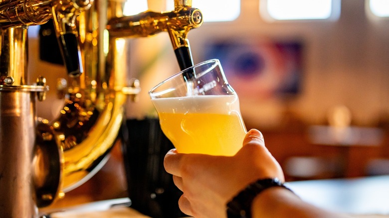 Person pouring beer into a glass from a tap