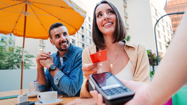 Couple paying bill at restaurant with card