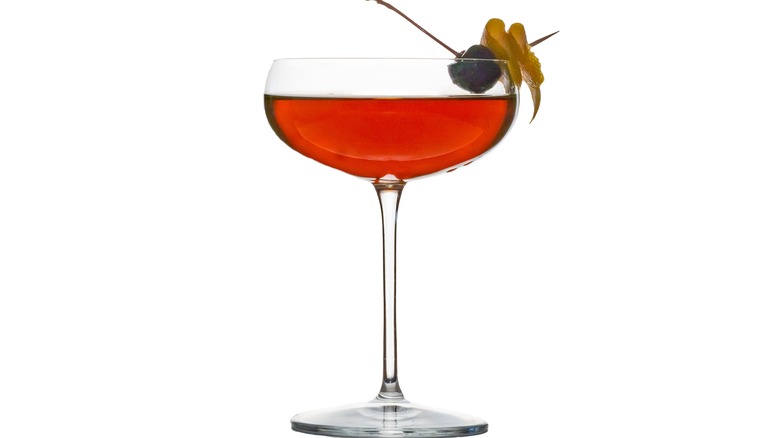 A Perfect Manhattan cocktail in a champagne glass on a white background