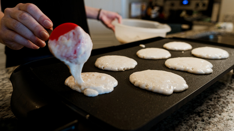 Pancake batter being poured onto a griddle
