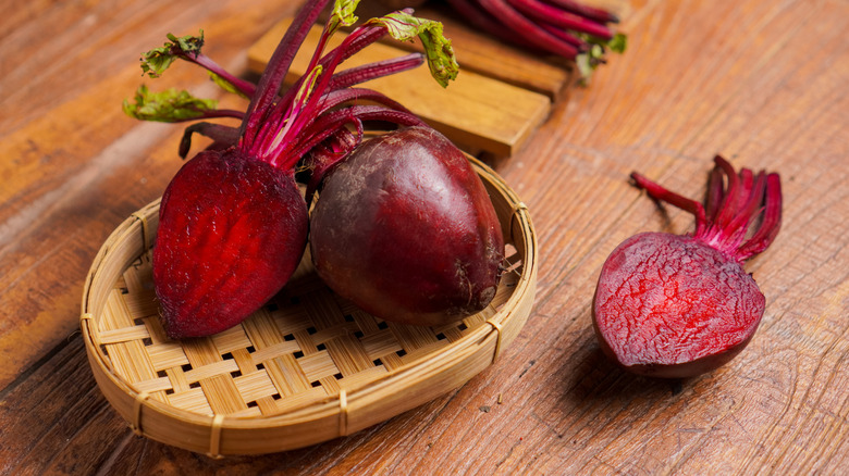 Sliced beets with stems on a wicker serving platter