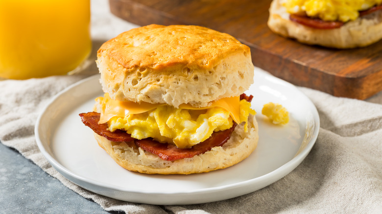 Bacon, egg, and cheese biscuit sandwich on a white plate