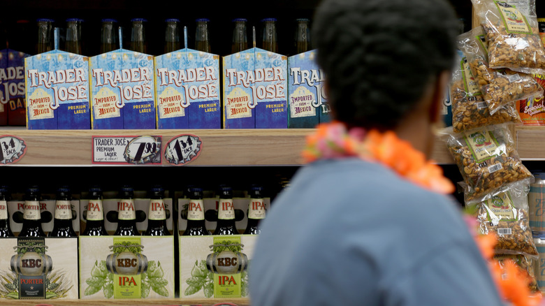 A woman examines shelves of beer for sale at a Trader Joe's store